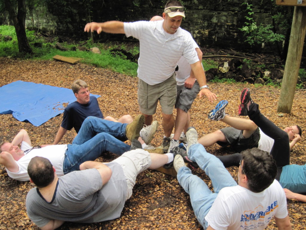 A group of 8 co-workers try to solve a team building puzzle.