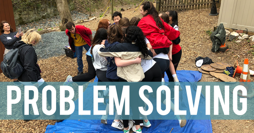 Group of teenagers huddled together on a blue tarp.